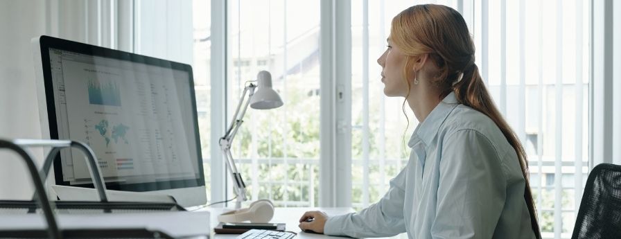 una donna lavora al computer seduta a una scrivania