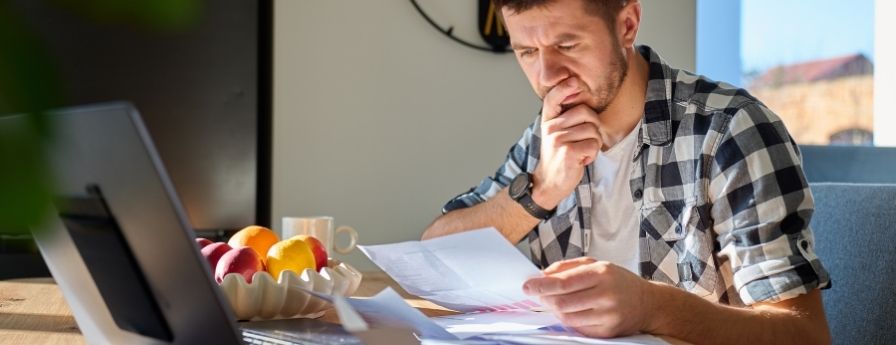 uomo che guarda dei documenti finanziari