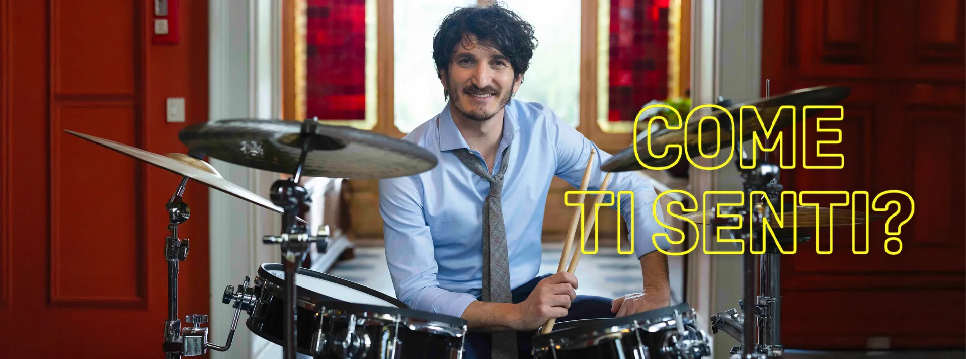 ragazzo che suona la batteria con scritta laterale che dice come ti senti?