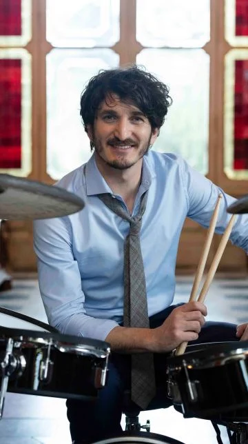 ragazzo che suona la batteria con scritta laterale che dice come ti senti?