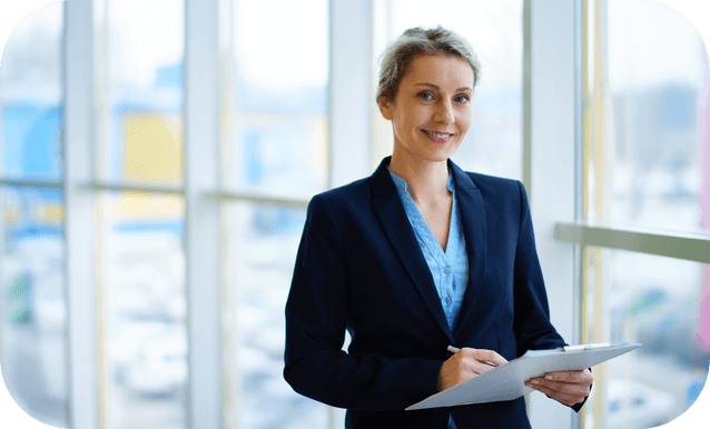 Donna in abito da lavoro che tiene un clipboard, pronta per prendere appunti o condurre un incontro