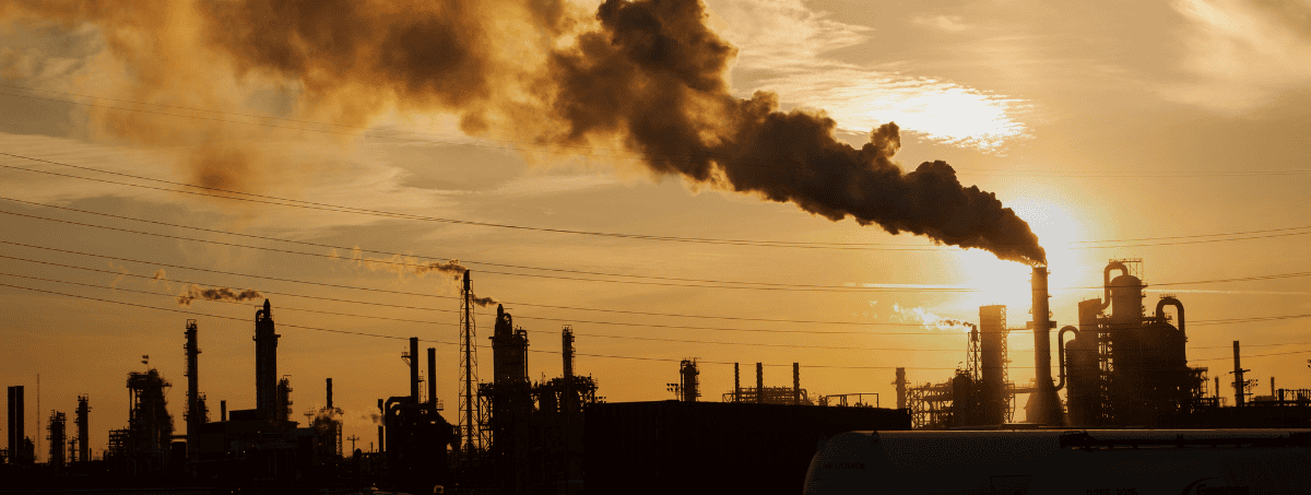 Una raffineria con fumi che escono dai camini, evidenziando l'attività industriale in corso