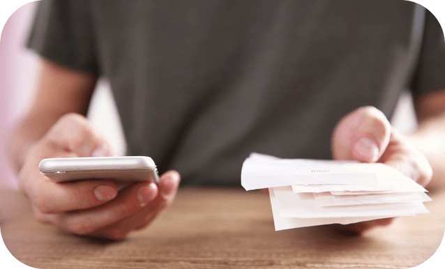 Individuo con un cellulare e un insieme di scontrini, pronto a gestire pagamenti
