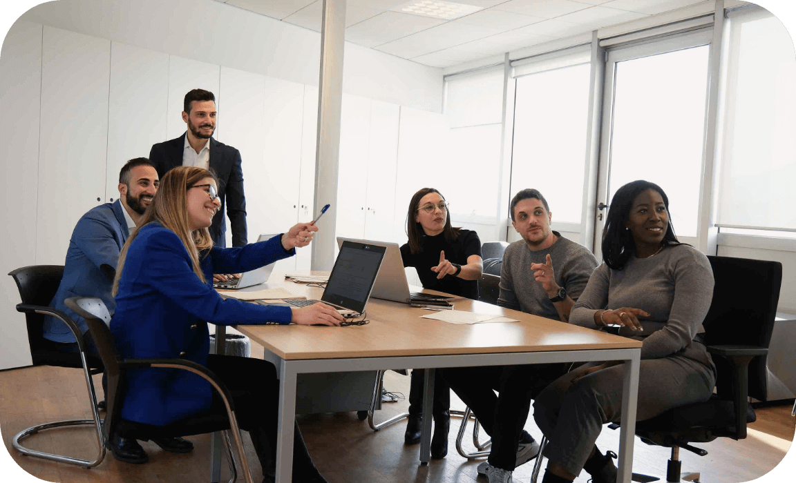 Team di giovani dipendenti Credem che stanno consultando in ufficio un lavagna il gestore del personale dedicato per la costruzione del tuo percorso professionale.,