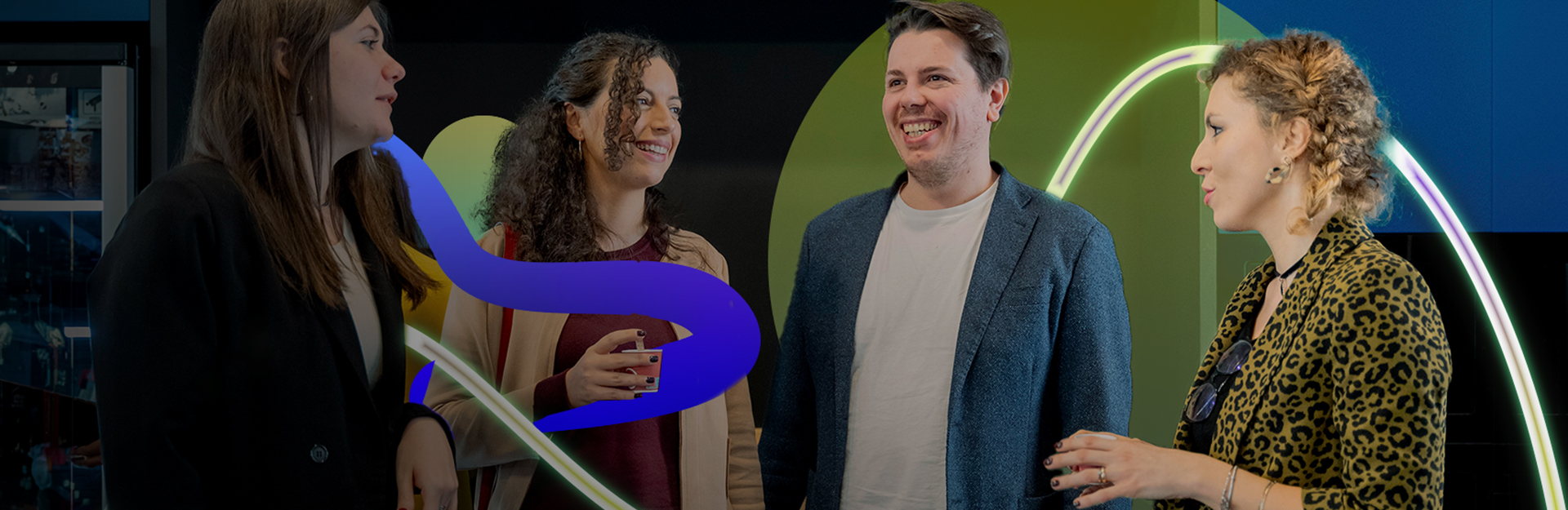 Quattro colleghi Credem che stanno sorridendo, contornati da una grafica a forme irregolari che sta a rappresentare l’energia positiva presente nell’ufficio.
