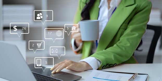 Donna in giacca verde che digita su un laptop, impegnata nell'accesso ai servizi di pagamento online.