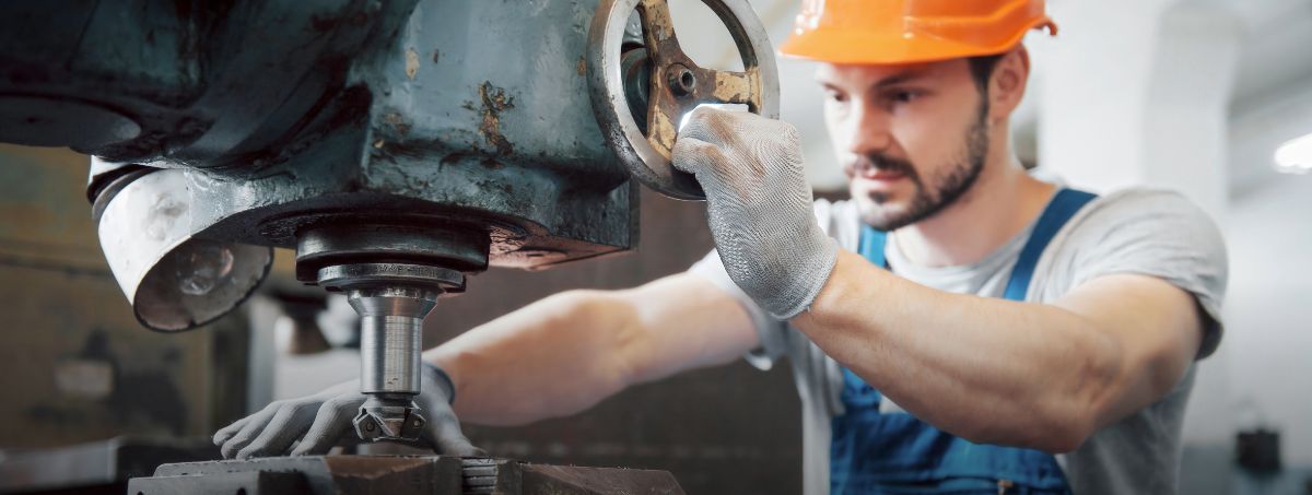 Un operaio lavora usando dei macchinari industriali