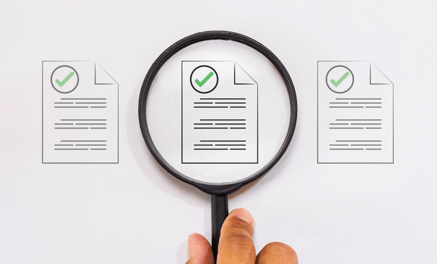 Una lente di ingrandimento evidenzia dei documenti