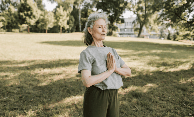 una signora che pratica yoga in un parco