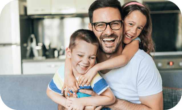 un padre abbraccia i suoi due figli piccoli in un momento di gioia