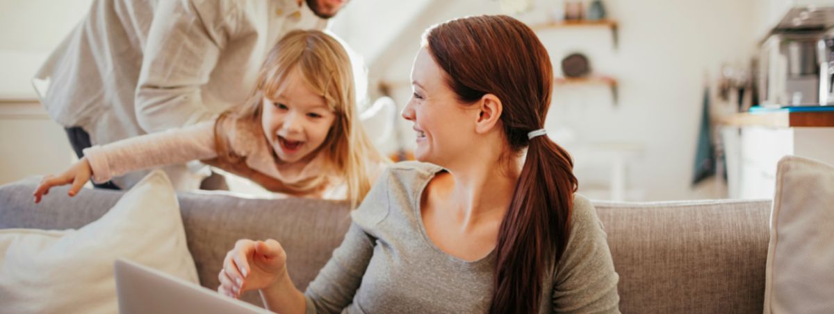 Una famiglia che giocano a casa con la figlia valutando i mutui Credem migliori per loro 