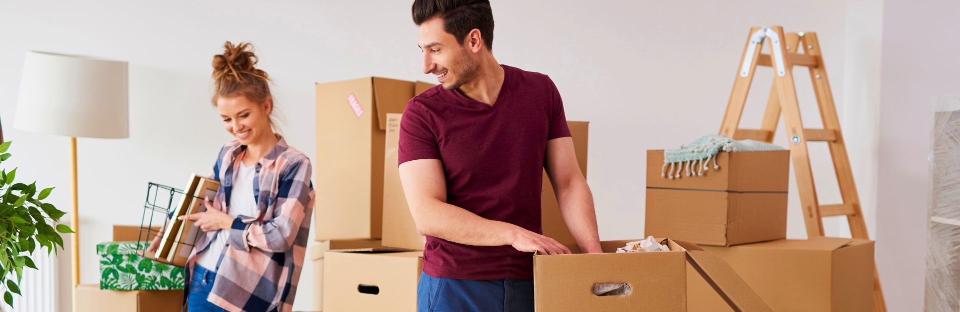 Coppia che sistema una serie di scatole per il trasferimento nella prima casa