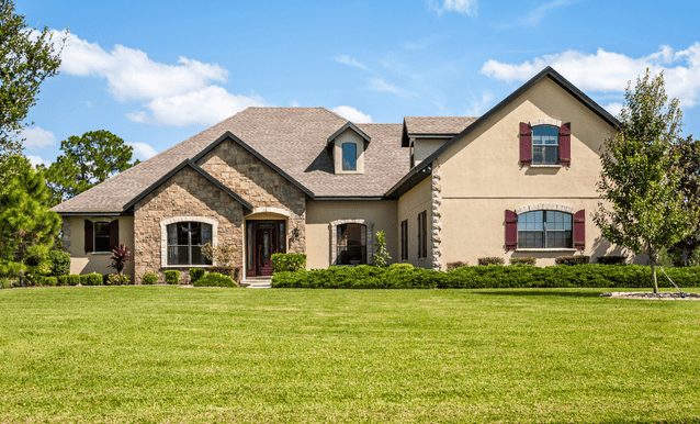 Una grande casa con un ampio giardino davanti.