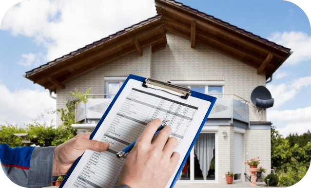 Persona che scrive dei dati su una tabella, con sullo sfondo una bella casa