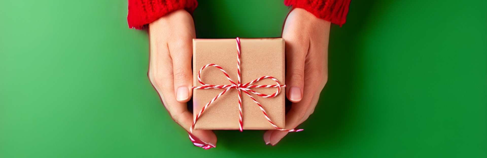 Mani che stringono un pacco regalo 