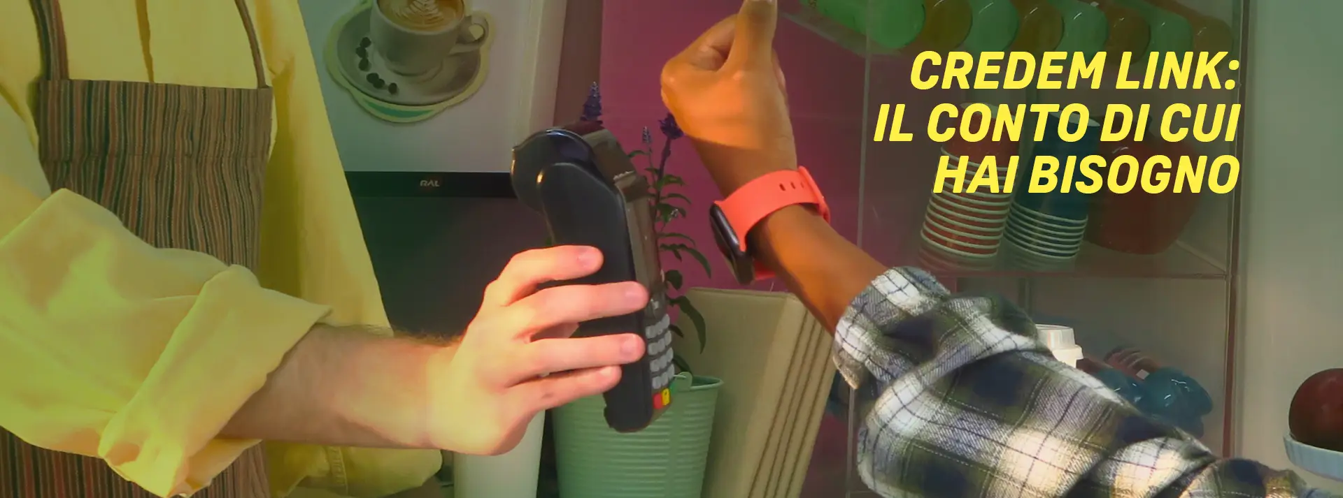 mano che utilizza uno smartwatch per pagare, di fianco la scritta credem link il conto di cui hai bisogno