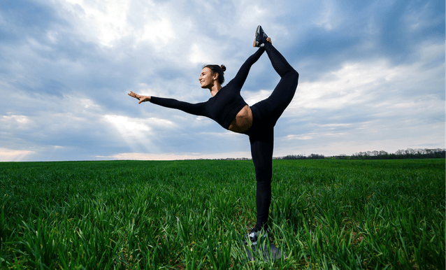 Ragazza in un prato che assume una posizione di yoga