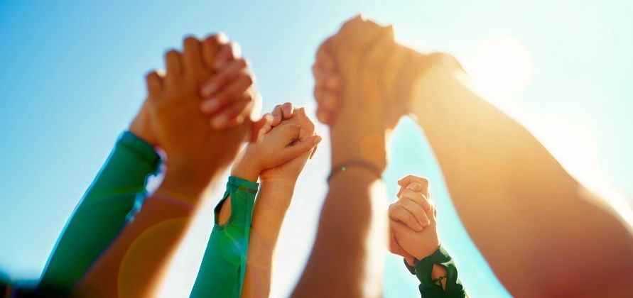 mani unite alzate al cielo in segno di solidarietà