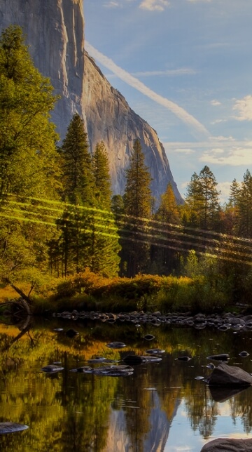 Paesaggio immerso nella natura con al centro un corso d'acqua e l'orizzonte una vallata. Ai lati delle alte montagne con il sole che sta per tramontare. “Prosperity”