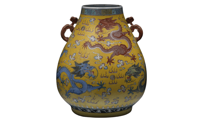Vaso in ceramica gialla dalla forma rotondeggiante con draghi in rosso e azzurro.