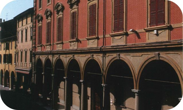 Veduta esterna di Palazzo Rusconi, palazzo rosso con archi al pian terreno.