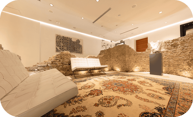Foyer con busto romano al centro e resti dell'aula absidata.