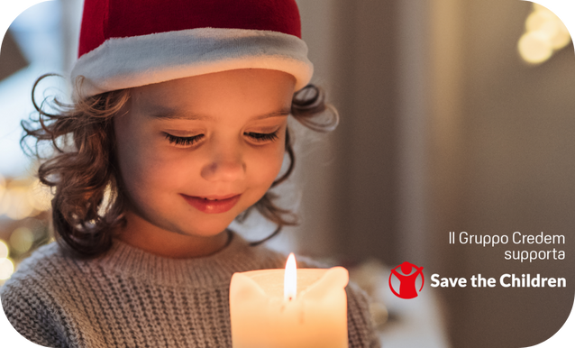 bambina che indossa cappello di babbo natale e tiene in mano una candela